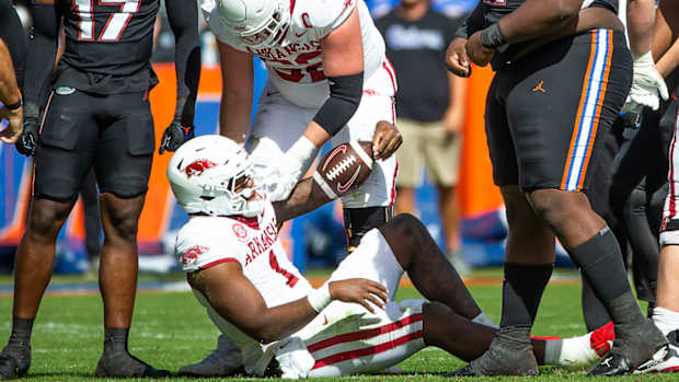 Razorbacks quarterback KJ Jefferson gets help from Brady Latham  after run against Florida